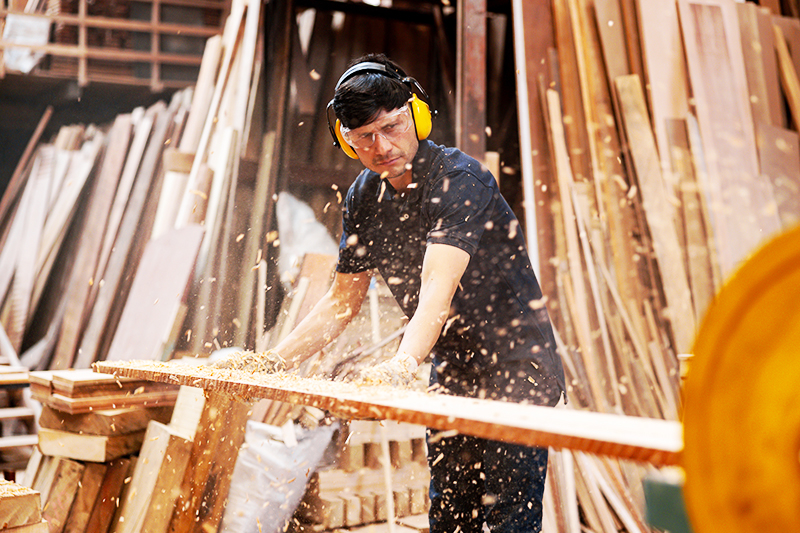 man wearing safety glasses while performing woodwork