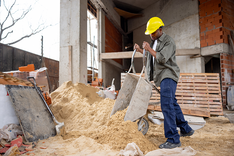construction worker filling sandbag by hand