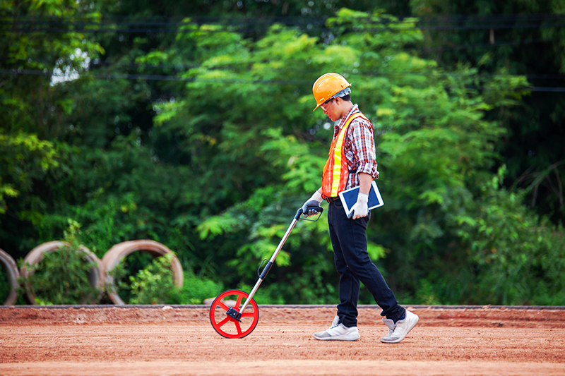 man holding measuring wheel