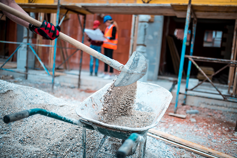 Construction worker filling a sandbag